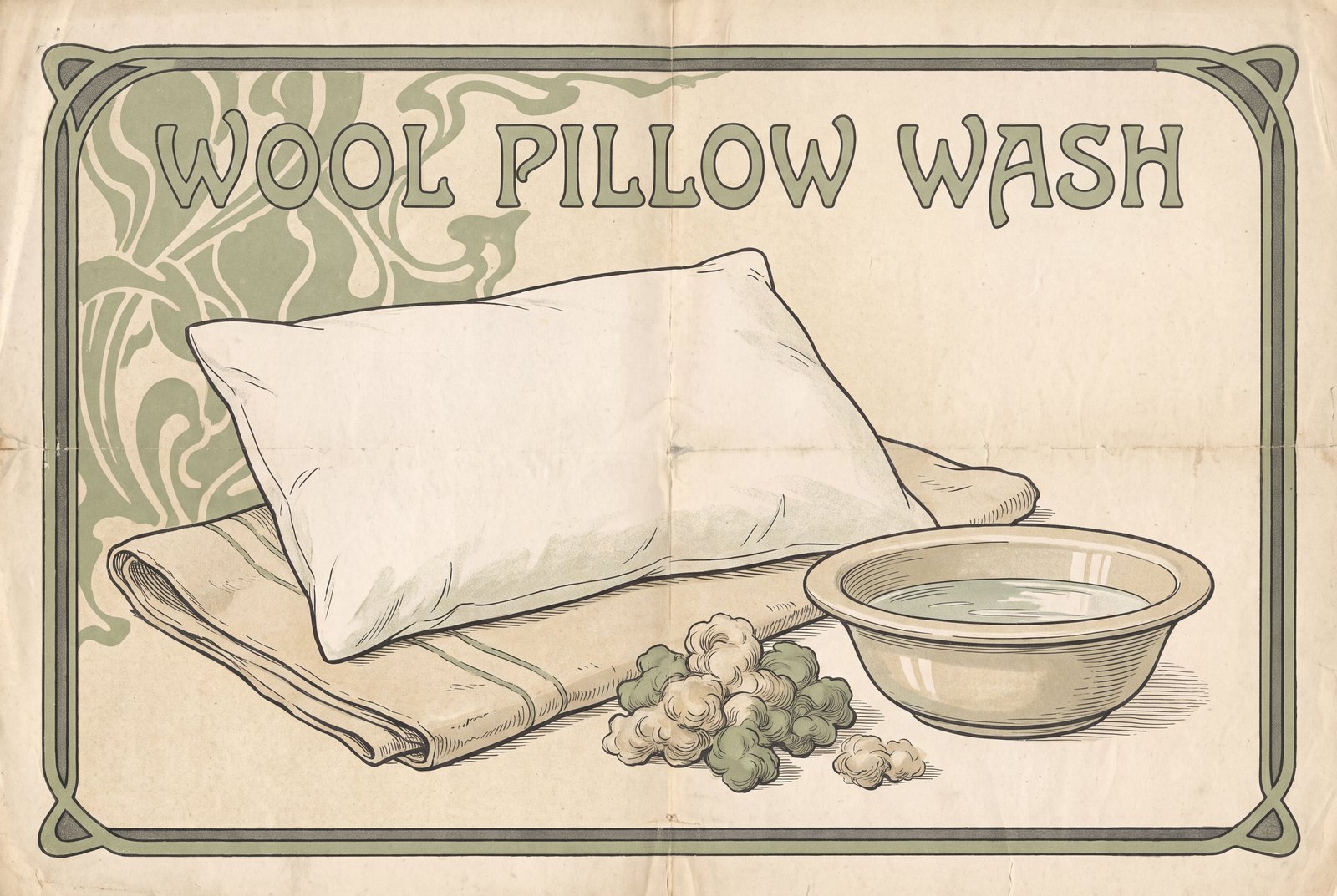A white pillow lies flat on a folded towel next to a shallow basin of water. A small heap of loose, fluffy wool clusters sits on the towel beside it.